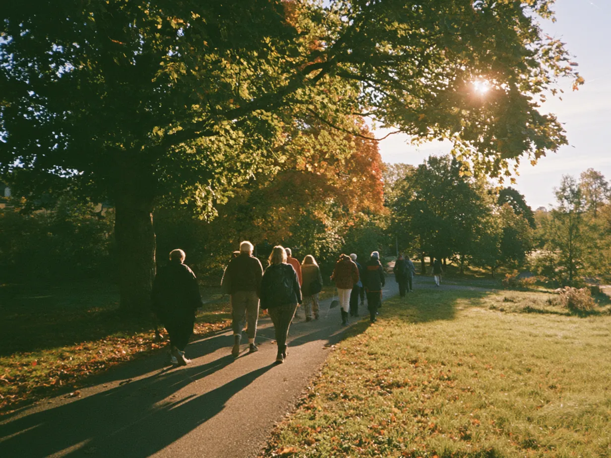 En promenadgrupp går tillsammans längs en parkväg en höstmorgon