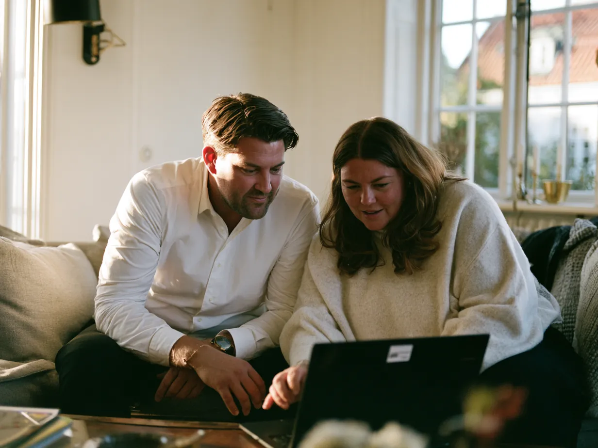 Par sitter i soffan och jämför alternativ på en dator