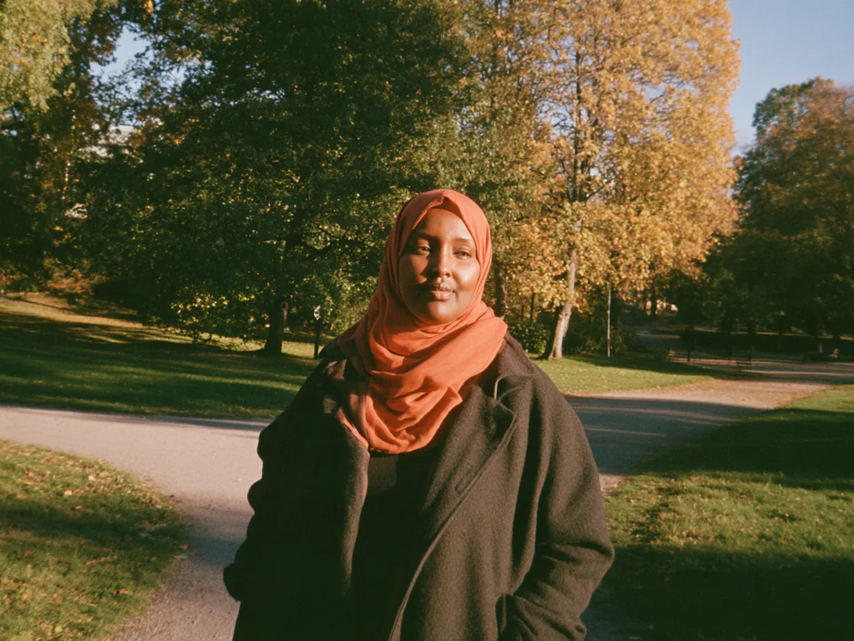 Kvinna i hijab står där en parkväg delar sig i två